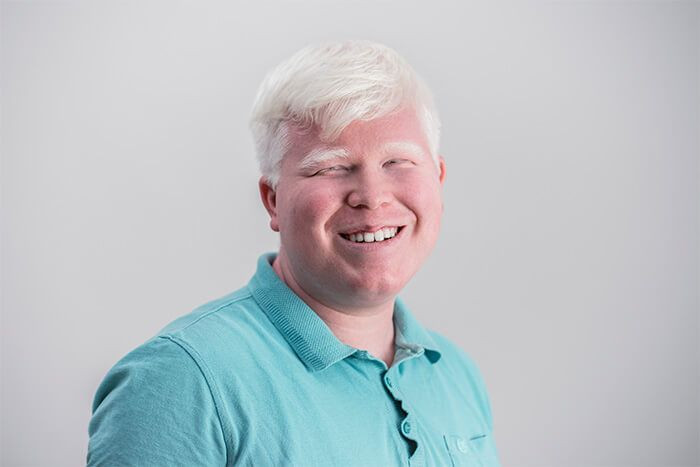 homem albino vestindo camisa polo azul.