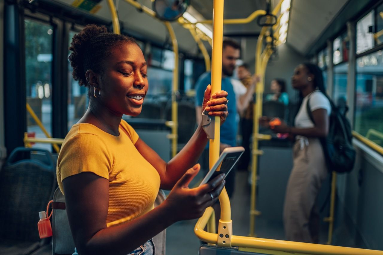 Mulher mexe no celular no transporte público.