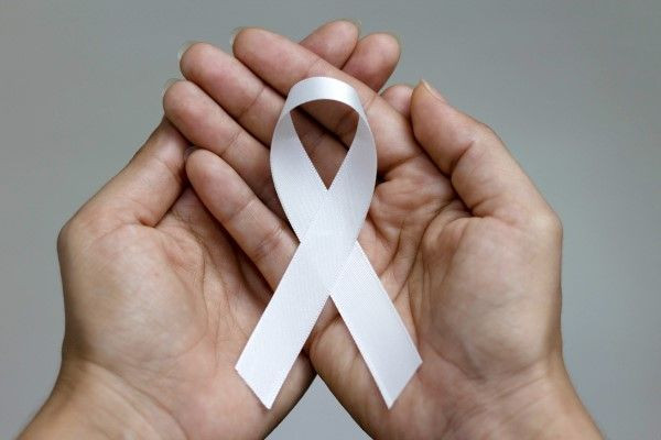 Pessoa com as mãos uma sobre a outra, com uma fita branca no meio, representando a campanha Janeiro Branco.