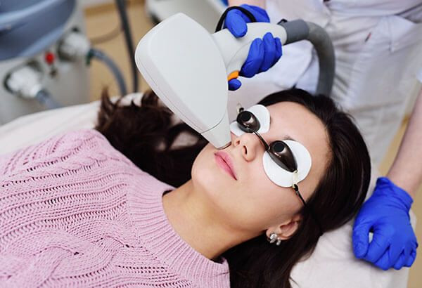 mulher em clínica fazendo depilação a laser no rosto para remover excesso de pelos.