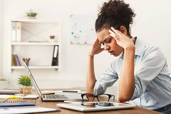 mulher com enxaqueca, que é um dos sintomas de sopro no coração